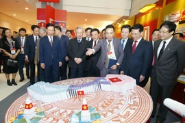 Ông Trần Quốc Vượng, Ủy viên Bộ Chính trị, Thường trực Ban Bí thư; ông Võ Văn Thưởng, Ủy viên Bộ Chính trị, Bí thư Trung ương Đảng, Trưởng Ban Tuyên giáo Trung ương và các đại biểu tham quan Trưng bày sách, báo tại Trung tâm Hội nghị quốc gia. (Ảnh: Doãn 