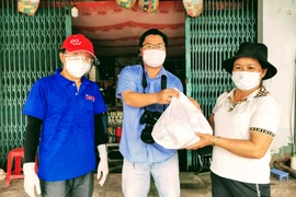 Các nhà hảo tâm đến trao quà hỗ trợ cho bệnh nhân chạy thận.(Ảnh: Thanh Liêm/TTXVN)