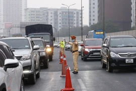 Lực lượng Cảnh sát giao thông làm nhiệm vụ phân luồng giao thông trên tuyến cao tốc Pháp Vân-Cầu Giẽ, nơi có mật độ lưu lượng người, phương tiện tham gia giao thông tăng do người dân trở về sau kỳ nghỉ Tết. (Ảnh: Doãn Tấn/TTXVN)