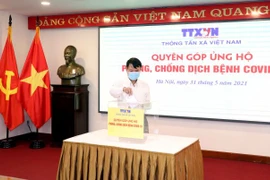 Tổng Giám đốc TTXVN Nguyễn Đức Lợi quyên góp, ủng hộ Quỹ phòng, chống dịch COVID-19. (Ảnh: Phạm Kiên/TTXVN)