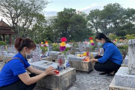 Các đoàn viên, thanh niên thắp nến tại các khu mộ ở Nghĩa trang Liệt sỹ Quốc gia Trường Sơn. (Ảnh: Thanh Thủy/TTXVN)