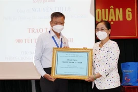  Bà Nguyễn Thị Lệ, Chủ tịch HĐND Thành phố Hồ Chí Minh thay mặt Thường trực HĐND Thành phố trao tặng 900 túi thuốc hỗ trợ gia đình cho Ban Chỉ đạo phòng, chống dịch COVID-19 quận 6. (Ảnh: Xuân Khu/TTXVN)