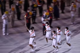 Các vận động viên rước đuốc Olympic tại lễ khai mạc Olympic Tokyo 2020 ở Tokyo, Nhật Bản, ngày 23/7. (Ảnh: AFP/TTXVN)