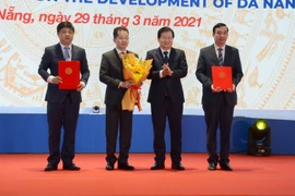 Phó Thủ tướng Chính phủ Trịnh Đình Dũng (thứ 2 từ phải sang) trao các nghị định, quyết định của Chính phủ cho lãnh đạo Thành ủy, UBND, HĐND thành phố Đà Nẵng. (Ảnh: Quốc Dũng/TTXVN)