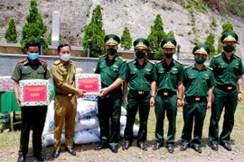 Tặng quà cho lực lượng vũ trang Lào ở vùng giáp biên. (Ảnh: Tường Vi/TTXVN)