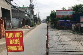 Lực lượng chức năng phong tỏa một đoạn đường TL19 (Khu phố 3B, phường Thạnh Lộc, quận 12, Thành phố Hồ Chí Minh). (Ảnh: Tiến Lực/TTXVN)