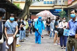 Nhân viên y tế Hà Nội tiến hành phun khử khuẩn toàn bộ nơi Trung tâm y tế quận Hoàn Kiếm tiến hành lấy mẫu xét nghiệm COVID-19 cho tất cả người dân từ Đà Nẵng trở về (ảnh chụp chiều 15/5). (Ảnh: Thành Đạt/TTXVN)