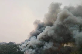 Đám cháy tạo ra cột khói đen bốc cao hàng chục mét. (Ảnh: Nguyễn Thắng/TTXVN)