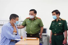 Trung tướng Nguyễn Hải Trung mong anh Nguyễn Trần Minh tiếp tục phát huy tinh thần dũng cảm, làm nhiều việc tốt hơn nữa, góp phần giữ gìn an ninh, trật tự. (Ảnh: TTXVN phát)