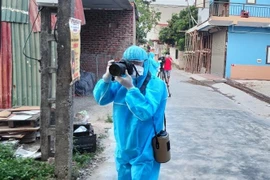 Phóng viên Danh Lam tác nghiệp trong tổ dân phố My Diềm 1, huyện Việt Yên (Bắc Giang). (Ảnh: TTXVN)