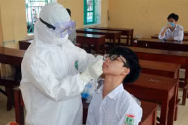 Lấy mẫu xét nghiệm COVID-19 cho học sinh ở Nam Định. (Nguồn: TTXVN)