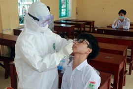 Lấy mẫu xét nghiệm COVID-19 cho học sinh ở Nam Định. (Nguồn: TTXVN)