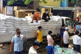 Bác sỹ và nhân viên y tế Bệnh viện Chợ Rẫy-Phnom Penh đã trích quỹ lương để mua ủng hộ 10 tấn gạo tặng cho 500 hộ gia đình trong đợt cứu trợ này. (Ảnh: Trần Ngọc Long/TTXVN)