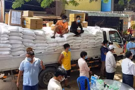 Bác sỹ và nhân viên y tế Bệnh viện Chợ Rẫy-Phnom Penh đã trích quỹ lương để mua ủng hộ 10 tấn gạo tặng cho 500 hộ gia đình trong đợt cứu trợ này. (Ảnh: Trần Ngọc Long/TTXVN)