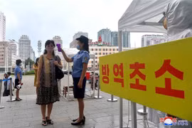 Đo thân nhiệt nhằm ngăn chặn sự lây lan của dịch COVID-19 tại Bình Nhưỡng, Triều Tiên. (Ảnh: AFP/TTXVN)