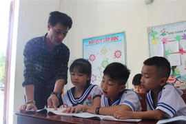  Thầy giáo Nguyễn Hữu Phú, Trường Tiểu học Song Tử Tây giảng bài cho học sinh khối lớp 3 của lớp ghép. (Ảnh: Phan Sáu/TTXVN)