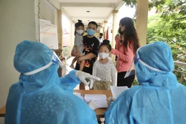 Người trở về từ Thành phố Hồ Chí Minh đến xét nghiệm COVID-19 tại địa điểm 26 Lương Ngọc Quyến (quận Hoàn Kiếm) trong ngày 10/7. (Ảnh: Minh Quyết/TTXVN)