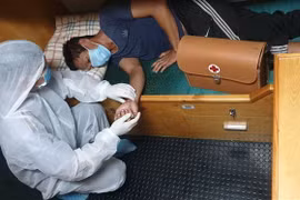 Ngư dân Đỗ Văn Hùng được cán bộ trên tàu kiểm ngư KN 462 sơ cứu ban đầu với các biện pháp phòng, chống dịch COVID-19. (Ảnh: TTXVN phát)