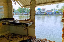 Một ngôi nhà bị sụp toàn bộ phần nhà phía sau xuống sông Trà Nóc (Cần Thơ). (Ảnh: Thanh Liêm/TTXVN)