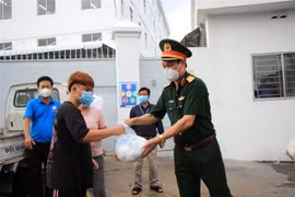 Tặng quà cho lao động nghèo, gặp khó khăn do ảnh hưởng dịch bệnh COVID-19 tại phường Hiệp Thành, Quận 12. (Ảnh: Xuân Khu/TTXVN)
