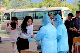 Công dân từ nước ngoài về nước rửa tay sát khuẩn tại khu cách ly tập trung. (Ảnh: Thanh Hải/TTXVN)