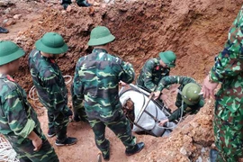 Lực lượng công binh tiến hành tháo gỡ quả bom. (Ảnh: TTXVN phát)