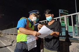 Lực lượng chức năng hướng dẫn tạo 'luồng xanh' cho các phương tiện vận tải. (Nguồn: TTXVN)