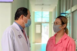 Bệnh nhân trò chuyện với bác sỹ phẫu thuật sau 15 ngày phẫu thuật. (Ảnh: Đinh Hằng/TTXVN)