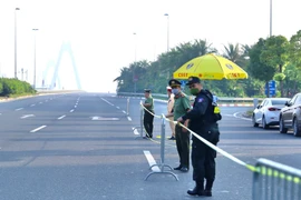 Từ 6h30, lực lượng chức năng lập rào chắn chuẩn bị triển khai chốt từ đường Võ Chí Công lên cầu Nhật Tân. (Ảnh: Hoàng Hiếu/TTXVN)