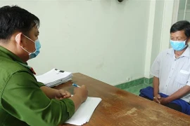 Phan Ngọc Phương (bìa phải) tại cơ quan điều tra. (Ảnh: TTXVN phát)