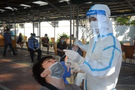 Người lao động làm việc tại Khu công nghiệp An Đồn (Đà Nẵng) được lấy mẫu xét nghiệm SARS-CoV-2 lần 2. (Ảnh: Văn Dũng/TTXVN)