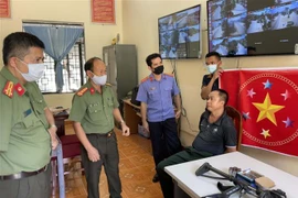 Lãnh đạo Công an tỉnh Sơn La lấy lời khai của đối tượng. (Ảnh: TTXVN phát)