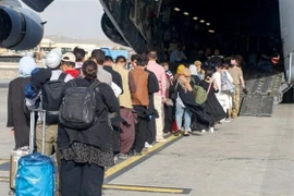 Người dân lên máy bay sơ tán khỏi Afghanistan tại Sân bay quốc tế ở Kabul. (Ảnh: Reuters/TTXVN)