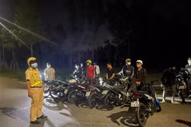 Lực lượng chức năng bắt giữ hơn 20 thanh niên tụ tập, đua xe, trong đó có nhiều người không đeo khẩu trang. (Ảnh: TTXVN phát)