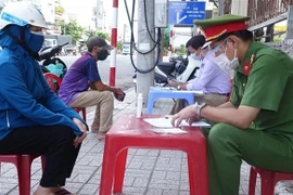 Các tổ công tác trên địa bàn thành phố Long Xuyên, tỉnh An Giang lập biên bản vi phạm hành chính trường hợp ra đường không thật sự cần thiết. (Ảnh: Công Mạo/TTXVN)
