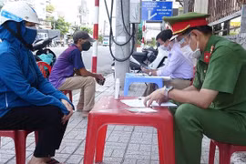 Các tổ công tác trên địa bàn thành phố Long Xuyên, tỉnh An Giang lập biên bản vi phạm hành chính trường hợp ra đường không thật sự cần thiết. (Ảnh: Công Mạo/TTXVN)