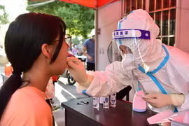Nhân viên y tế lấy mẫu xét nghiệm COVID-19 cho người dân tại tỉnh Phúc Kiến, Trung Quốc. (Ảnh: THX/TTXVN)