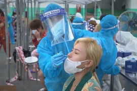 Công ty Hansol vina phối hợp cùng Trung tâm y tế thành phố Dĩ An, tỉnh Bình Dương lấy mẫu gộp sàng lọc cho toàn bộ 4.000 người lao động tại nhà máy. (Ảnh: TTXVN phát)