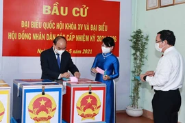 Chủ tịch nước Nguyễn Xuân Phúc cùng Phu nhân và Bí thư Thành ủy Thành phố Hồ Chí Minh Nguyễn Văn Nên bỏ phiếu bầu đại biểu Quốc hội khóa XV và Hội đồng nhân dân các cấp nhiệm kỳ 2021-2026. (Ảnh: Thống Nhất/TTXVN)