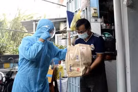 Đại diện Liên đoàn Lao động thành phố Thủ Đức trao tặng quà cho người lao động gặp khó khăn do dịch COVID-19. (Ảnh: Thanh Vũ/TTXVN)