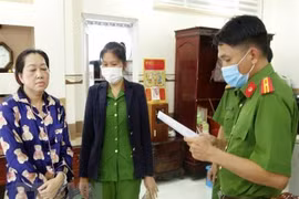 Cơ quan điều tra đọc lệnh khám xét nhà Nguyễn Thị Kim Hạnh đối tượng cầm đầu vụ vận chuyển trái phép 51kg vàng qua biên giới. (Ảnh: TTXVN phát)