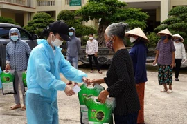 Trao tặng quà cho các hộ nghèo, hộ cận nghèo, người có hoàn cảnh khó khăn... tại phường Biên Giang, quận Hà Đông. (Ảnh: Tuấn Anh/TTXVN)