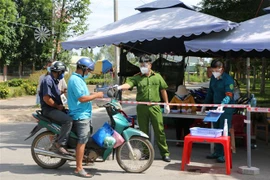 Lực lượng chức năng làm việc tại chốt kiểm soát phòng, chống dịch COVID-19 tại thị trấn Thạnh Hóa, huyện Thạnh Hóa. (Ảnh: Thanh Bình/TTXVN)