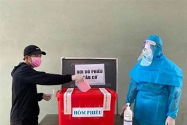 Cử tri tại khu cách ly tập trung ở huyện Bàu Bàng, tỉnh Bình Dương được thực hiện quyền nghĩa vụ của mình trong ngày đi bầu cử. (Ảnh: TTXVN phát)
