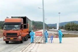Lực lượng chức năng siết chặt công tác kiểm soát dịch bệnh COVID-19 đối với phương tiện xuất nhập khẩu hàng hóa. (Ảnh: TTXVN phát)