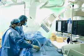 Êkíp các bác sỹ tiến hành nút mạch cứu sống bệnh nhân. (Ảnh: TTXVN phát)