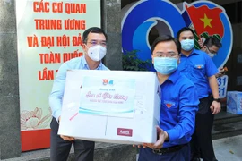 Anh Nguyễn Anh Tuấn, Ủy viên Ban Chấp hành, Bí thư thứ nhất Ban Chấp hành Trung ương Đoàn vận chuyển nhu yếu phẩm lên xe để vận chuyển đến cho các lực lượng phòng, chống COVID-19 tuyến đầu. (Ảnh: Minh Đức/TTXVN)