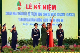 Thượng tướng Võ Minh Lương, Thứ trưởng Bộ Quốc phòng gắn Huân chương lên lá cờ truyền thống của Bộ Tư lệnh Vùng Cảnh sát biển 3. (Ảnh: Đoàn Mạnh Dương/TTXVN)