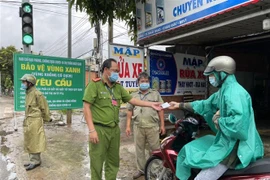 Người dân xuất trình giấy tờ đi đường tại một chốt 'vùng xanh" ở Bà Rịa-Vũng Tàu. (Ảnh: Hoàng Nhị/TTXVN)