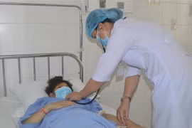 Các bác sỹ Bệnh viện Đa khoa Trung ương Cần Thơ thăm khám cho bệnh nhân Đ.T.T sau phẫu thuật. (Ảnh: TTXVN phát)
